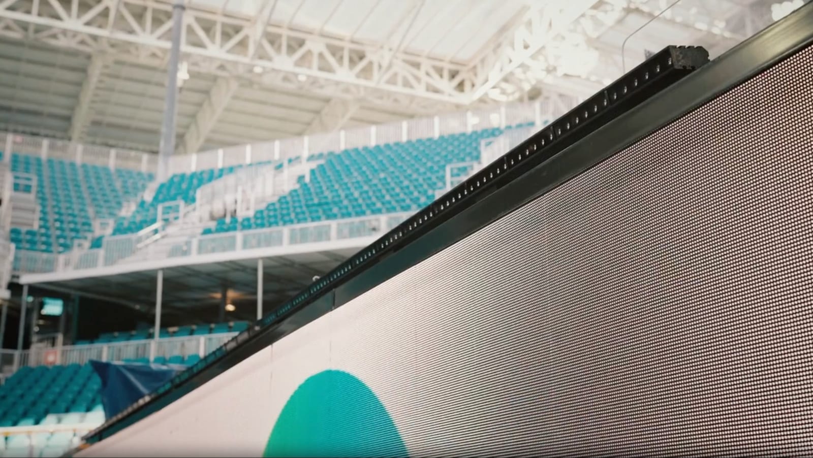 A slim black Muybridge sensor bar running the length of the courtside LED board inside the Miami Open stadium